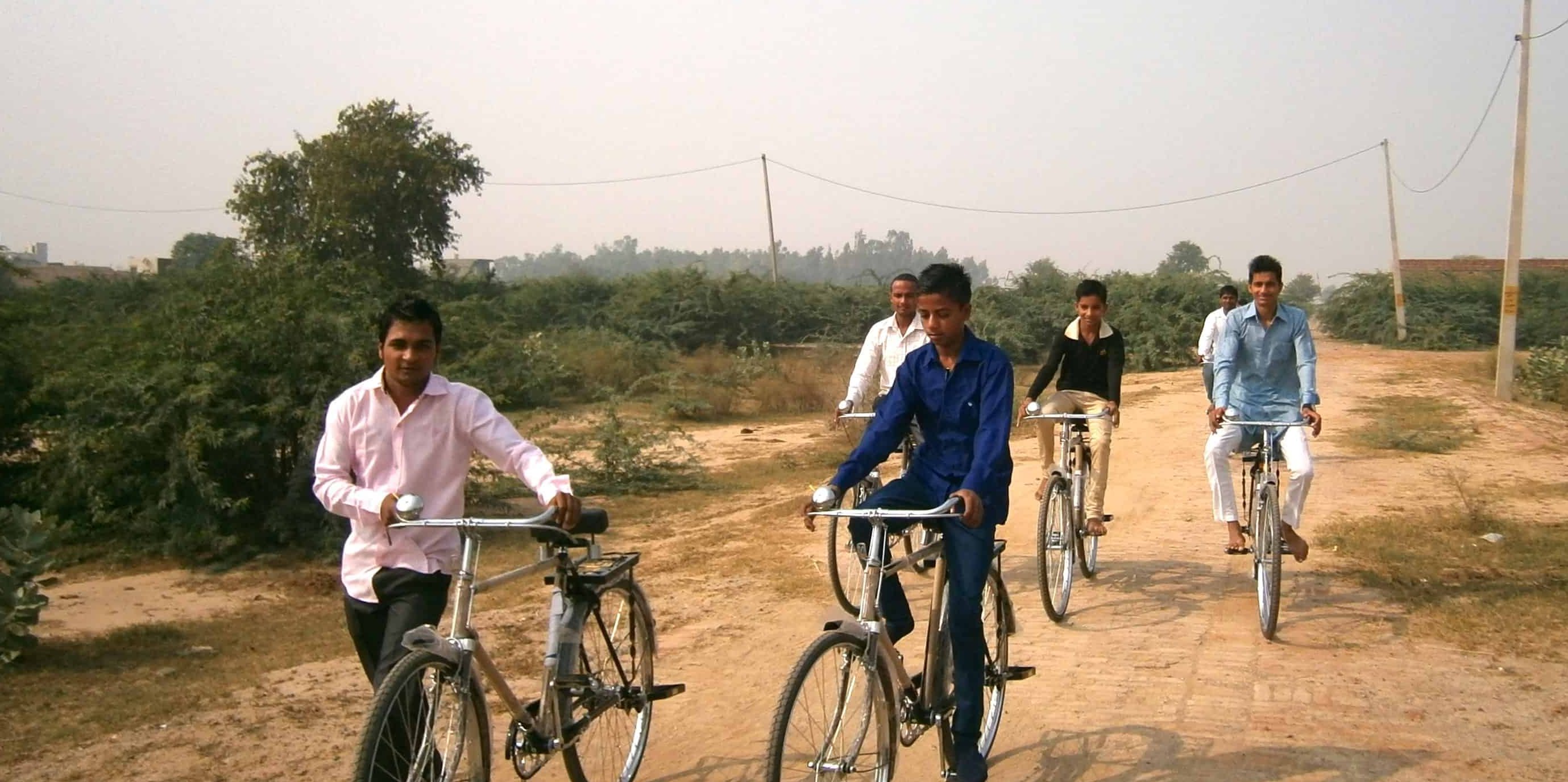 Foto van afgestudeerde leerlingen van de bijbelschool met hun gesponsorde fietsen